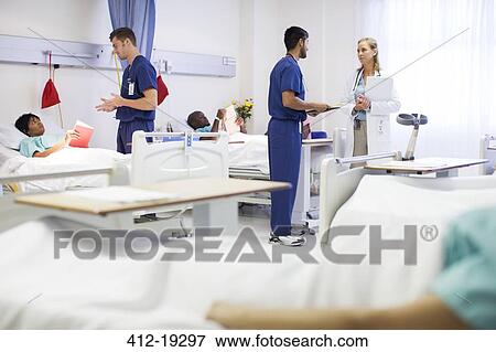 Doctor, nurses, and patients in hospital room View Large Photo Image Stock Photo - Doctor, nurses, and patients in hospital room. Fotosearch