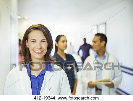 Doctor smiling in hospital hallway View Large Photo Image Picture - Doctor smiling in hospital hallway. Fotosearch