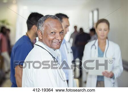 Doctor smiling in hospital hallway View Large Photo Image Picture - Doctor smiling in hospital hallway. Fotosearch
