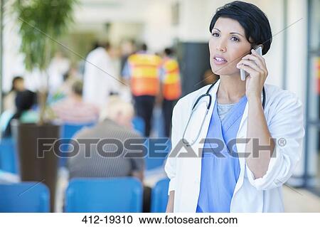 Doctor talking on cell phone in hospital View Large Photo Image Stock Image - Doctor talking on cell phone in hospital. Fotosearch