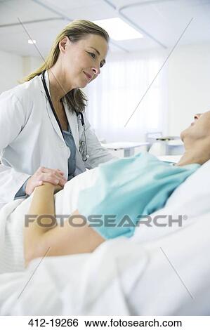 Stock Photograph - Doctor talking to patient in hospital room. Fotosearch