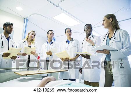Doctor teaching residents in hospital room View Large Photo Image Stock Photo - Doctor teaching residents in hospital room. Fotosearch