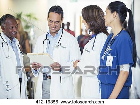 Doctors and nurse talking in hospital hallway View Large Photo Image Stock Photograph - Doctors and nurse talking in hospital hallway. Fotosearch