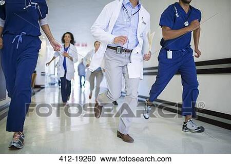 Stock Image - Doctors and nurses rushing in hospital hallway. Fotosearch