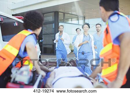 Doctors and nurses rushing to patient on ambulance stretcher View Large Photo Image Picture - Doctors and nurses rushing to patient on ambulance stretcher. Fotosearch