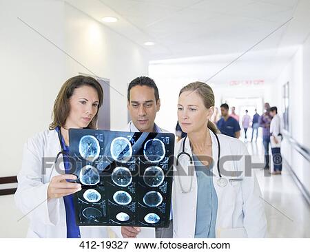 Doctors examining x-rays in hospital hallway View Large Photo Image Stock Photo - Doctors examining x-rays in hospital hallway. Fotosearch
