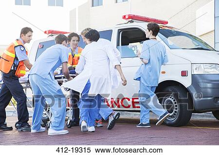 Doctors, nurses, and paramedic examining patient on stretcher View Large Photo Image Stock Photography - Doctors, nurses, and paramedic examining patient on stretcher. Fotosearch
