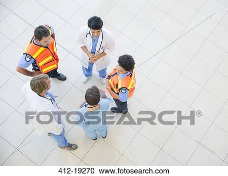 Stock Image - Doctors, nurses, and paramedics talking in hospital. Fotosearch