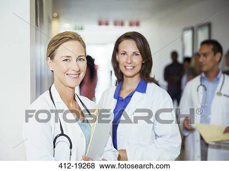 Doctors smiling in hospital hallway View Large Photo Image Stock Photo - Doctors smiling in hospital hallway. Fotosearch