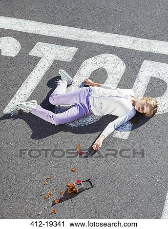 Stock Image - Injured girl laying in street. Fotosearch