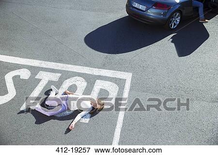 Stock Photo - Injured girl laying in street. Fotosearch