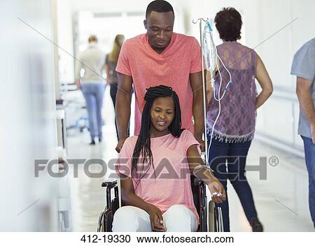 Man wheeling girlfriend in hospital hallway View Large Photo Image Stock Image - Man wheeling girlfriend in hospital hallway. Fotosearch