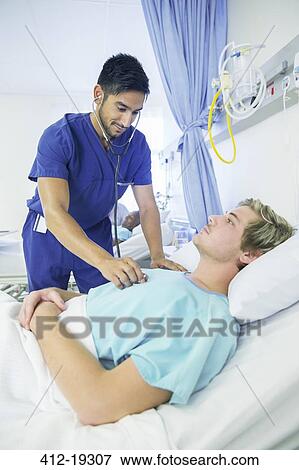 Nurse examining patient in hospital room View Large Photo Image Stock Photo - Nurse examining patient in hospital room. Fotosearch