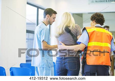 Stock Image - Paramedic and nurse helping patient in hospital. Fotosearch