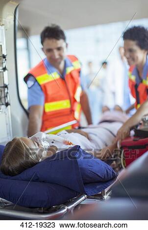 Paramedics examining patient on ambulance stretcher View Large Photo Image Stock Image - Paramedics examining patient on ambulance stretcher. Fotosearch