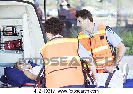 Stock Photo - Paramedics examining patient on stretcher. Fotosearch
