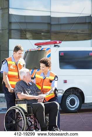 Stock Photo - Paramedics greeting patient in wheelchair. Fotosearch