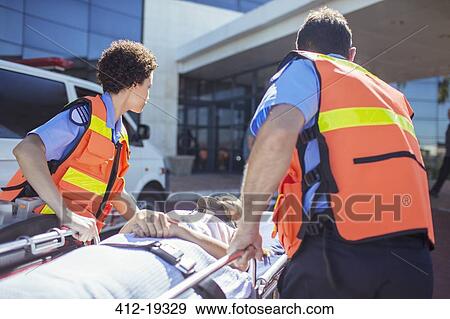 Stock Photo - Paramedics wheeling patient in hospital parking lot. Fotosearch
