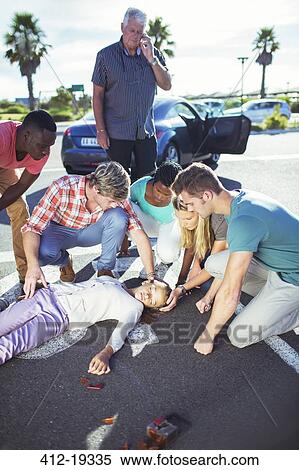 Stock Photography - People examining injured girl on street. Fotosearch