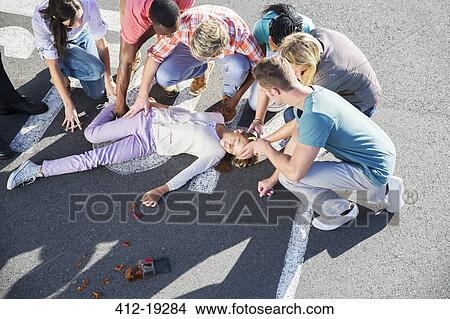 Picture - People rushing to injured girl on street. Fotosearch