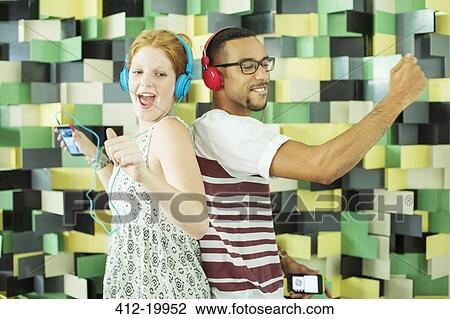 Friends listening to headphones together View Large Photo Image Stock Image - Friends listening to headphones together. Fotosearch