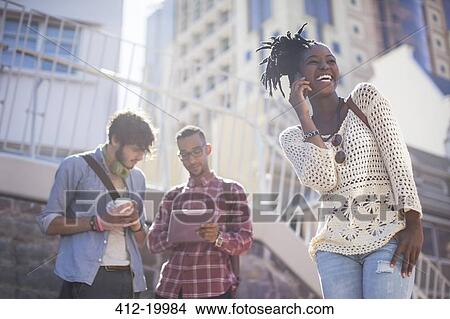 Picture - Friends relaxing together on city street. Fotosearch
