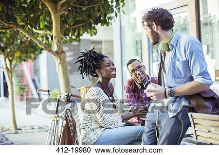 Stock Image - Friends talking on city street. Fotosearch