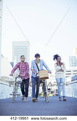 Stock Image - Friends walking on city street. Fotosearch