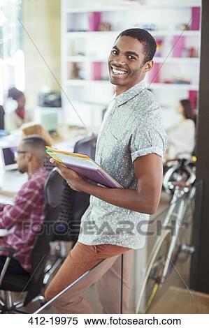 Man carrying folders in office View Large Photo Image Stock Photography - Man carrying folders in office. Fotosearch