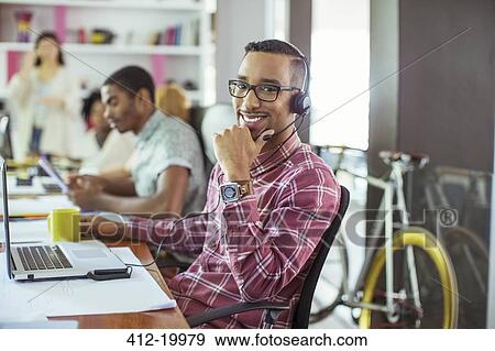 Man smiling at desk in office View Large Photo Image Stock Photo - Man smiling at desk in office. Fotosearch