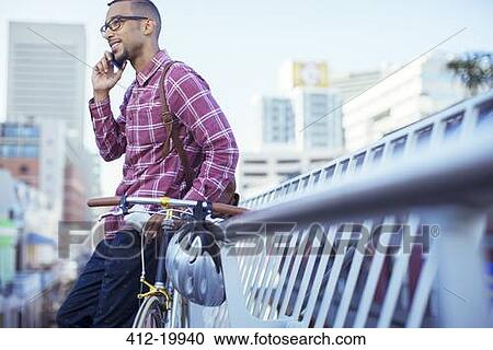 Man talking on cell phone on city street View Large Photo Image Stock Image - Man talking on cell phone on city street. Fotosearch