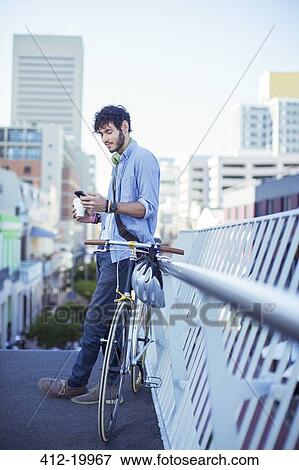 Stock Photo - Man using cell phone on city street. Fotosearch