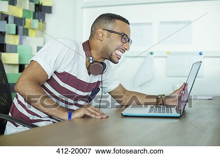 Man working at laptop in office View Large Photo Image Stock Photo - Man working at laptop in office. Fotosearch