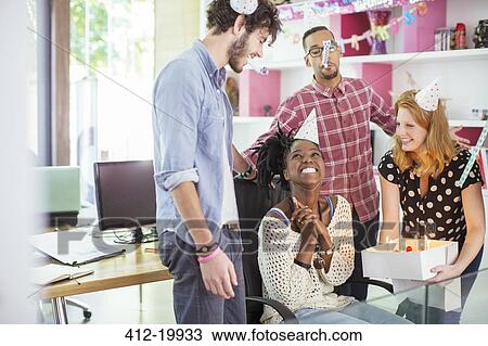Stock Image - People celebrating birthday in office. Fotosearch