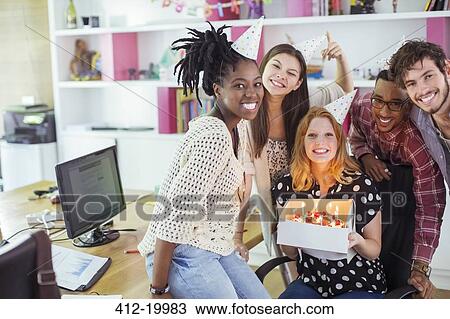 Stock Image - People celebrating birthday in office. Fotosearch