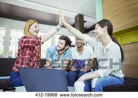People high fiving in office View Large Photo Image Stock Photo - People high fiving in office. Fotosearch