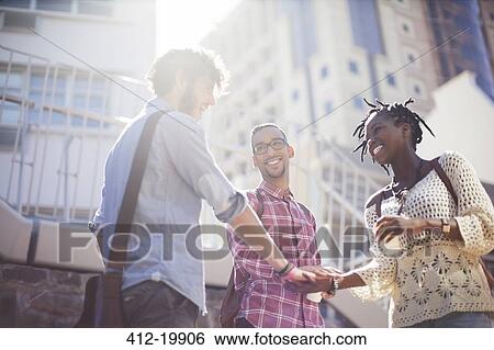 Stock Photograph - People shaking hands on city street. Fotosearch