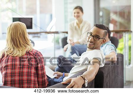People smiling in office lobby area View Large Photo Image Stock Photograph - People smiling in office lobby area. Fotosearch