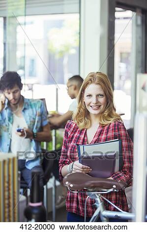 Woman carrying folders in cafe View Large Photo Image Stock Image - Woman carrying folders in cafe. Fotosearch