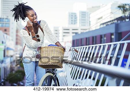 Picture - Woman talking on cell phone on city street. Fotosearch