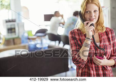 Woman talking on phone in office View Large Photo Image Stock Photo - Woman talking on phone in office. Fotosearch