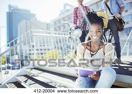 Woman using digital tablet on city street View Large Photo Image Picture - Woman using digital tablet on city street. Fotosearch
