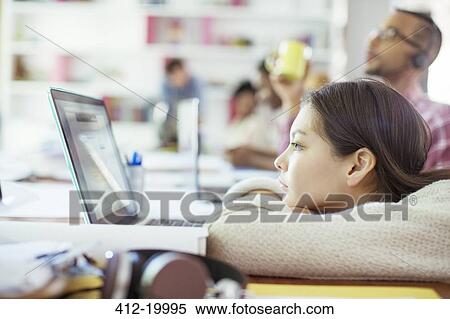 Woman using laptop at conference table in office View Large Photo Image Stock Photography - Woman using laptop at conference table in office. Fotosearch