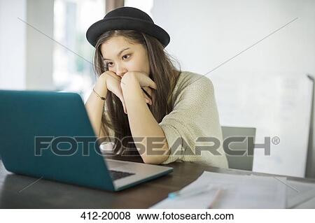 Stock Photo - Woman working at laptop in office. Fotosearch