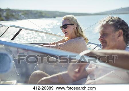 Couple driving boat in water View Large Photo Image Stock Photo - Couple driving boat in water . Fotosearch
