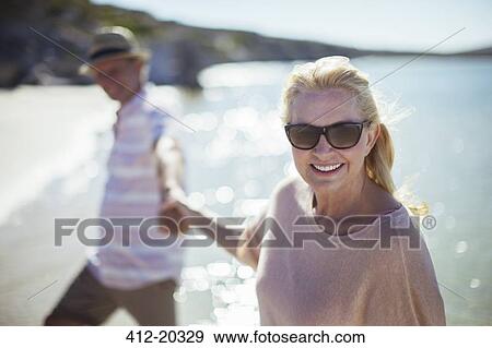 Stock Photo - Couple holding hands on beach. Fotosearch