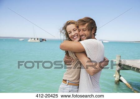 Stock Photography - Couple hugging near water . Fotosearch