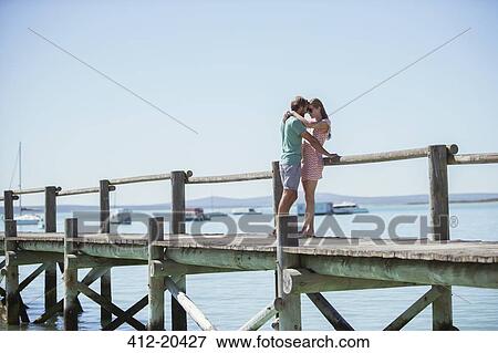 Couple hugging on wooden dock View Large Photo Image Stock Photo - Couple hugging on wooden dock . Fotosearch