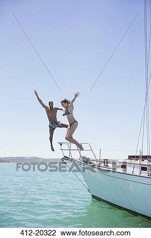 Couple jumping off boat into water View Large Photo Image Stock Image - Couple jumping off boat into water . Fotosearch
