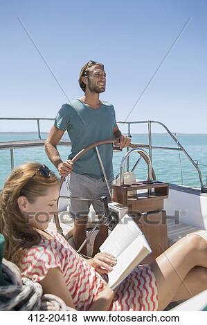 Stock Photo - Couple relaxing in boat on water. Fotosearch